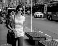Black and white street scene, young woman striding down Queen St, Auckland